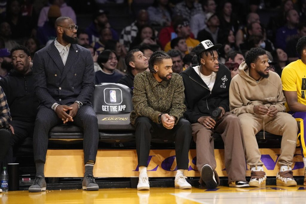 Lakers star LeBron James, left, sits on the bench with the newly acquired (from left) D’Angelo Russell, Jarred Vanderbilt and Malik Beasley (Los Angeles Lakers) (Mark J. Terrill / Associated Press)