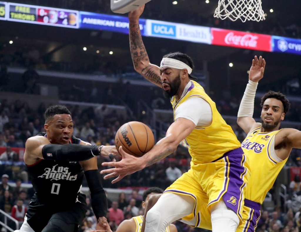 Clippers guard Russell Westbrook turns the ball over to Lakers power forward Anthony Davis in the first quarter Wednesday at Crypto.com Arena.(Luis Sinco / Los Angeles Times)
